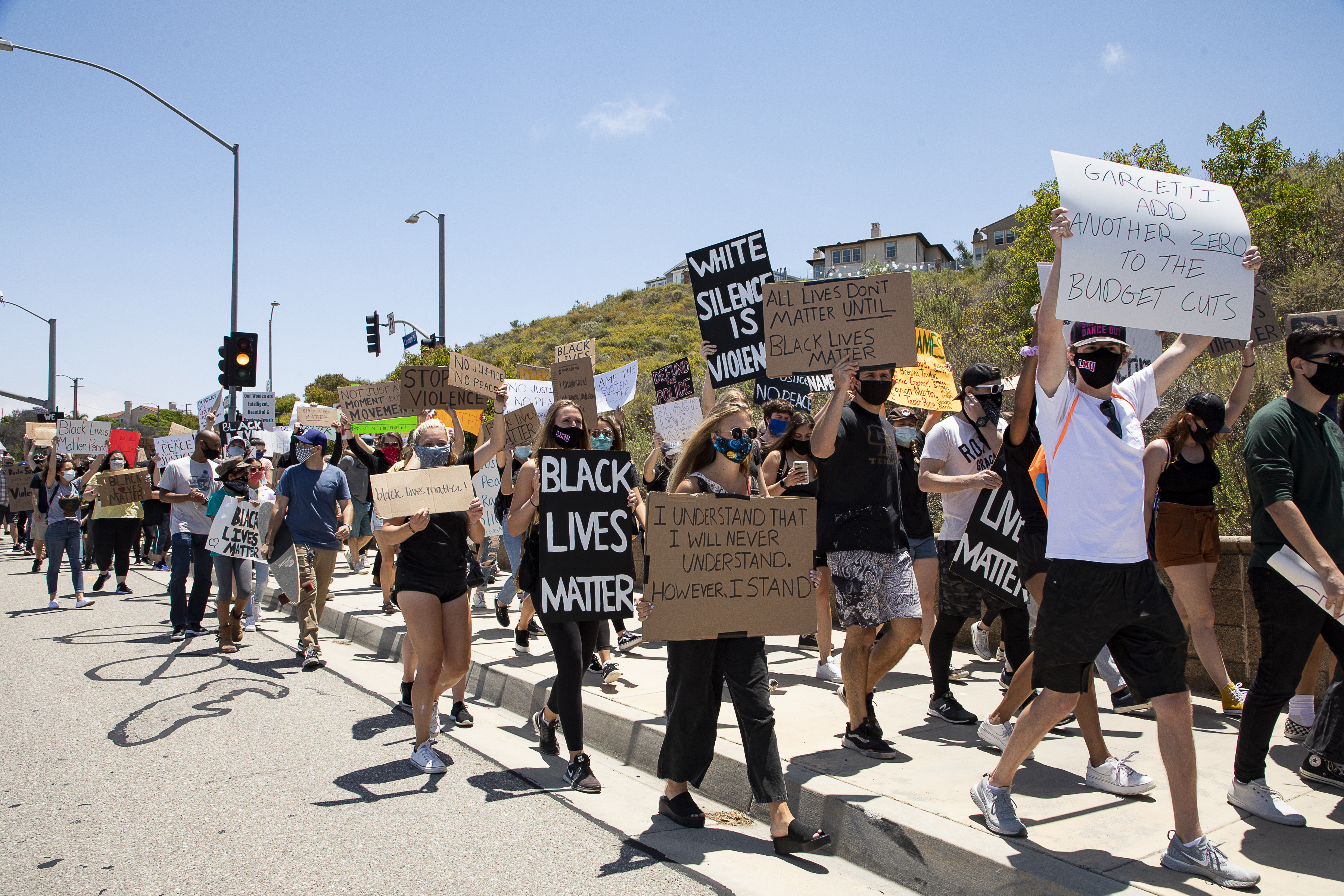 image of protesters marching with signs outside of LMU. The center sign reads Black Lives Matter